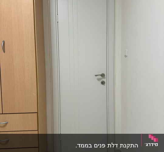 דלת לבנה עם ידית מתכת בחדר פנימי